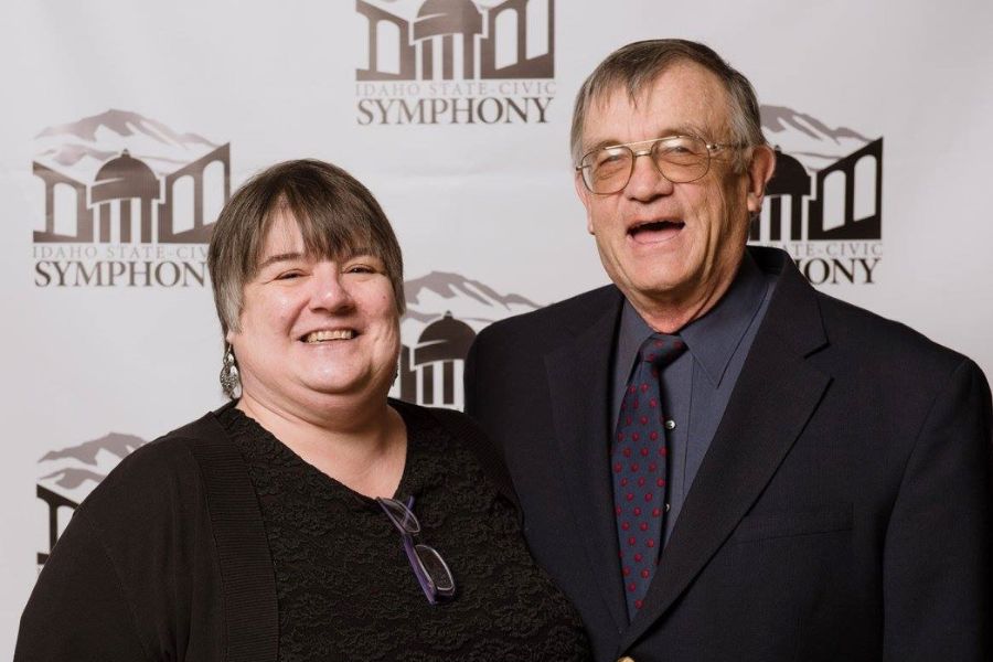 Grant and Donna Thomas smile in front of the Idaho State Civic Symphony backdrop